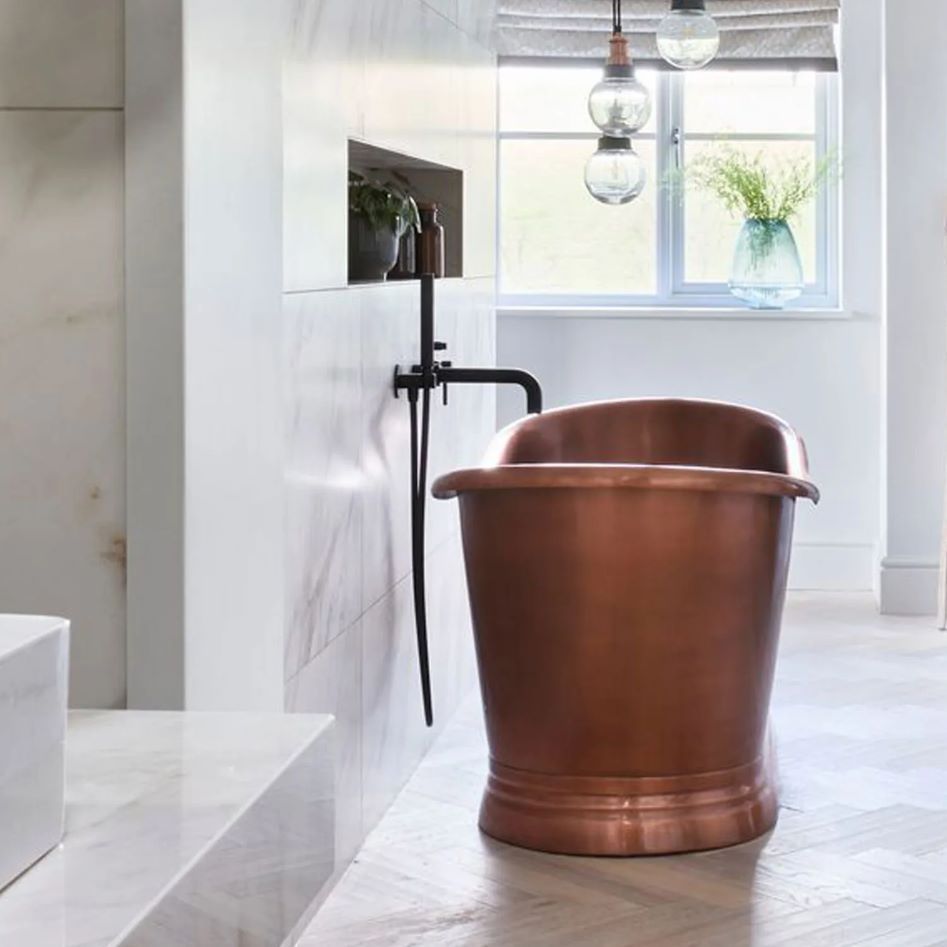 Coppersmith Creations Slanted Cascading Base Copper Bathtub Full Antique Finish installed in home with light tiled room